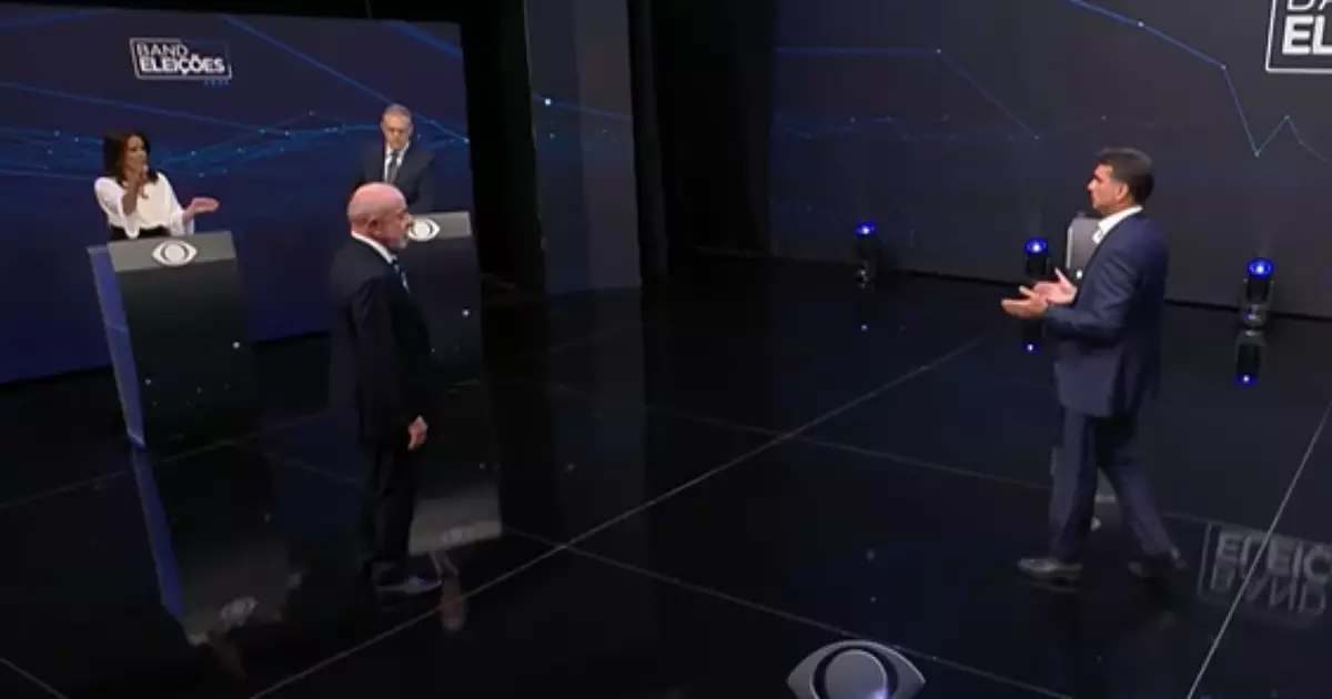 Apresentadora dá bronca em Flávio Bolsonaro e Lula durante debate: 'Vamos respeitar'